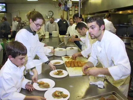 James Passafaro helping plate dishes with the team at Perona Farms