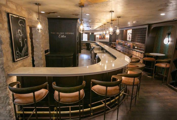 The curved bar and leather stools at The Blind Horse Cellar in Cedarburg, Wisconsin